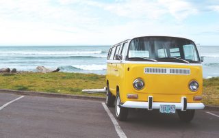 A Freshly Detailed & Clean Yellow VW Camper Van in a Car Park on the Coastline